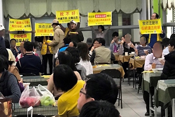 圖說:1月29日中午,法稅改革聯盟志工出現在中區國稅局餐廳,舉牌發傳單,提醒國稅局官員,切勿觸犯刑法第129條違法徵收罪。