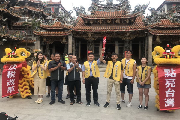 圖:顏寬恒由法稅改革聯盟青年志工手中接下聖火,期許法稅真改革,聖火點亮台灣。
