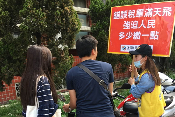 法稅改革聯盟志工舉牌宣導法稅常識